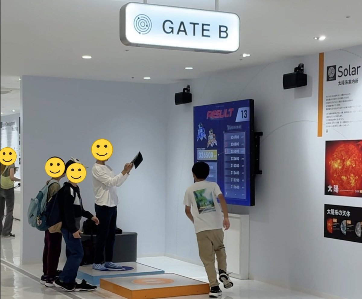 重力の違いを体感するゲームの結果画面を見上げる子どもたち